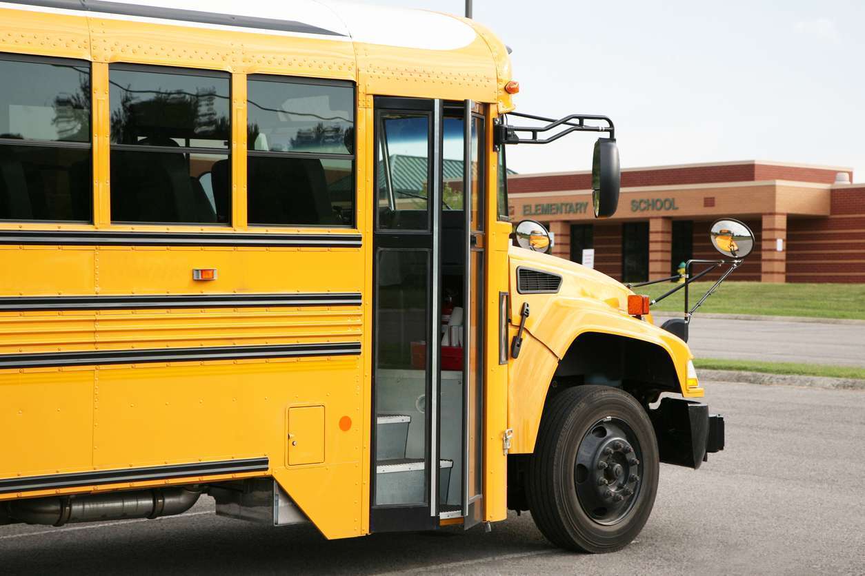 Yellow bus in front of a school